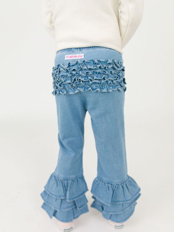 rufflebutts ruffle flare denim jeggings Child wearing blue ruffled pants and white sweater.