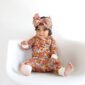 Baby in floral outfit with matching headband