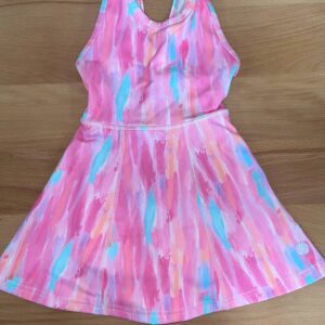 Colorful pink toddler dress on wooden surface.
