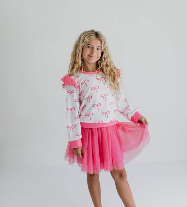 product Girl wearing pink bow-patterned outfit.