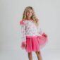 Girl wearing pink bow-patterned outfit.