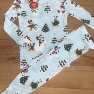 Disney-themed pajamas with Christmas patterns on wood surface.