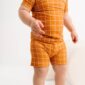 Child wearing orange checkered clothes, white background