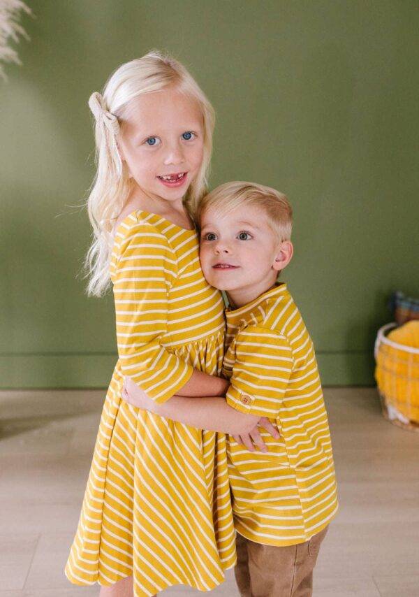 ollie jay alex tee in mustard stripe Children in yellow striped outfits hugging each other.