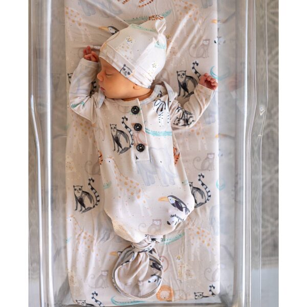 gigi and max bamboo baby gown Newborn sleeps in animal-patterned outfit.