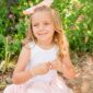 Smiling child with bow in sunny garden