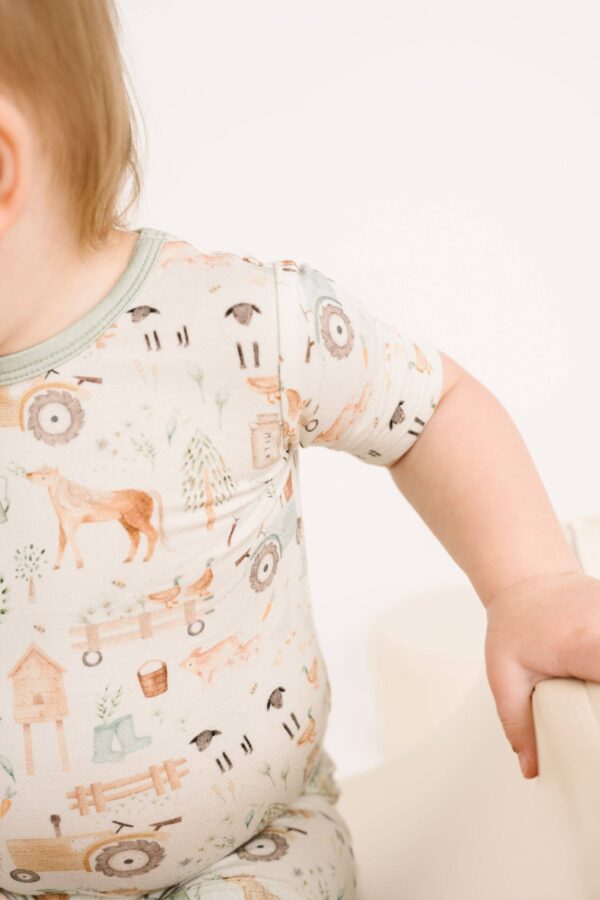 little one shop little farm bamboo shorts set Baby wearing farm-themed outfit with tractor pattern.
