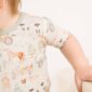 Baby wearing farm-themed outfit with tractor pattern.
