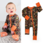 Baby wearing camo onesie with orange accents.