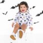 Smiling child in Halloween outfit with bat decorations.