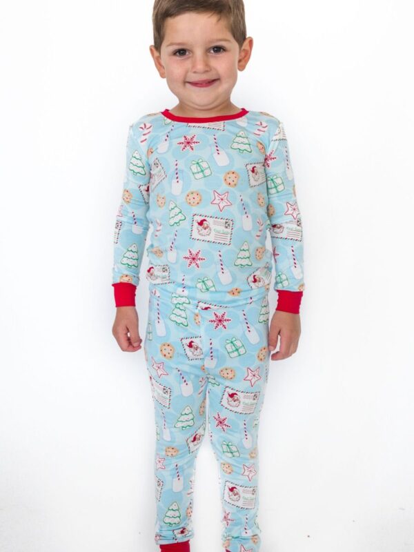 rufflebutts santa sweets pajamas Child wearing festive Christmas pajamas smiling.