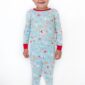 Child wearing festive Christmas pajamas smiling.