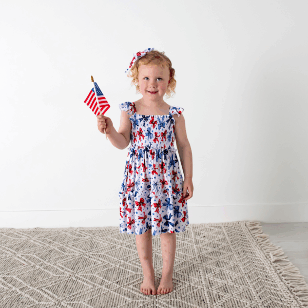 gigi and max eleanor bow clip bow 4th of july hair accessory Child in patriotic dress holding American flag