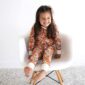 Smiling child in floral pajamas on chair