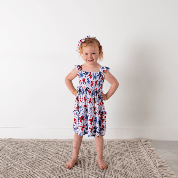 gigi and max eleanor bow clip bow 4th of july hair accessory Smiling girl wearing patterned dress and matching headband.