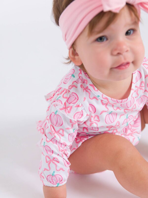 rufflebutts + ruggedbutts baby girls pink fairytale pumpkins knit long sleeve flutter bubble romper Baby in pink headband and patterned outfit