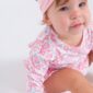 Baby in pink headband and patterned outfit