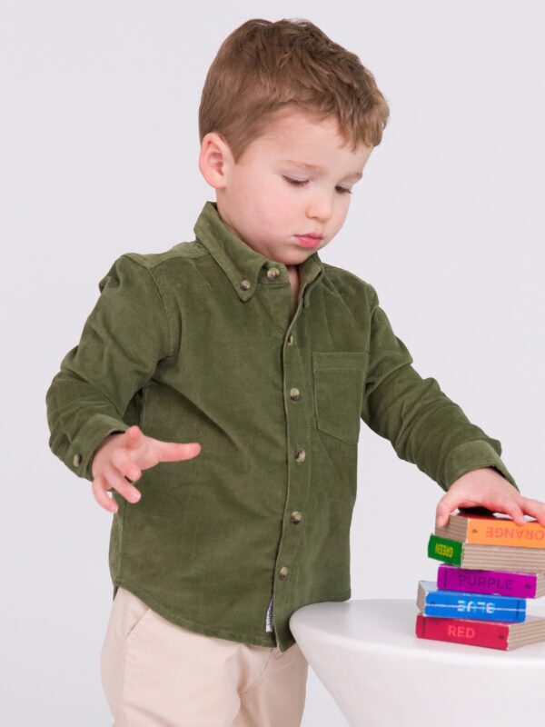 Child stacking colorful books on white table