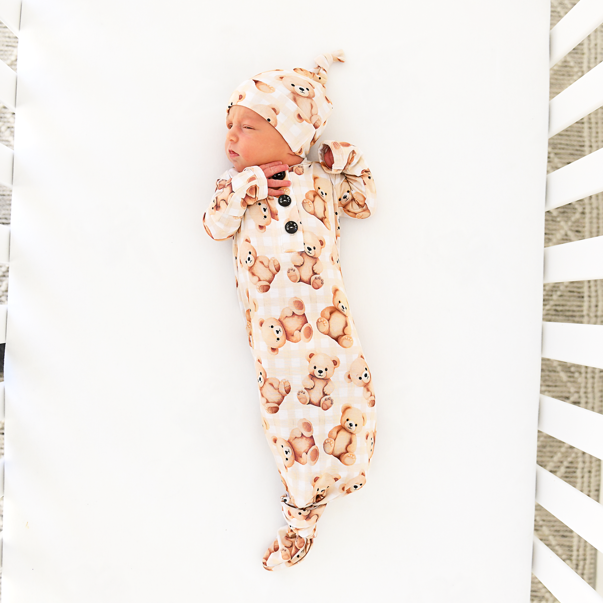 Newborn in teddy bear pajamas sleeps peacefully