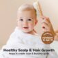 Baby's scalp gently brushed for healthy hair growth.
