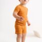 Toddler in orange grid-patterned outfit.