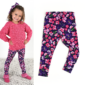 Girl in floral leggings with pink sweater and bow.