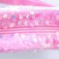 Pink sequin bag with heart-shaped charm.