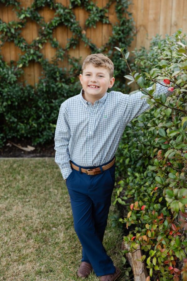 j. bailey roscoe button down murphy Smiling child standing by garden hedge.