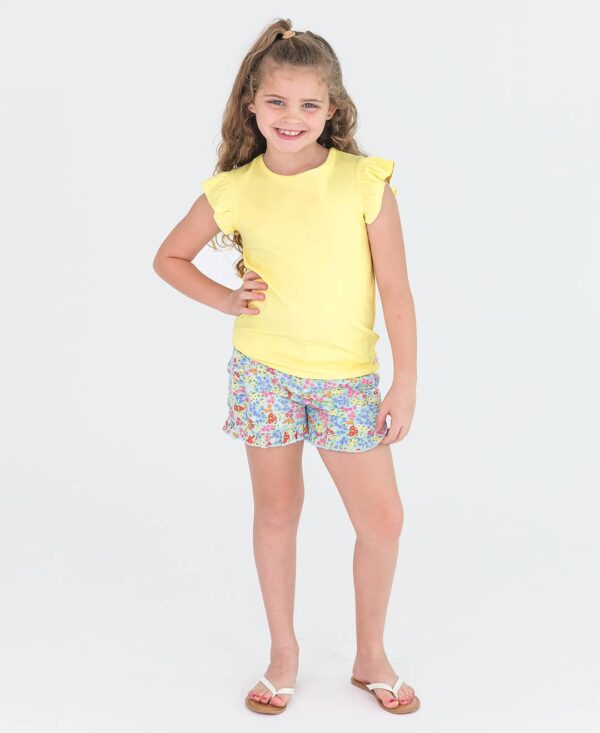rufflebutts girls petaling around ruffle trim woven shorts and yellow ribbded top set Child in yellow shirt and floral shorts smiling.