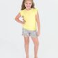 Child in yellow shirt and floral shorts smiling.