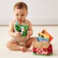 Baby playing with farm-themed learning toy.