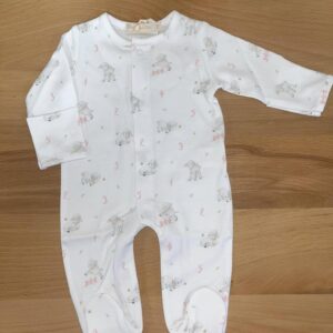 White baby onesie with lamb pattern on wooden surface.