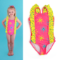 Smiling child in colorful sun-patterned swimsuit