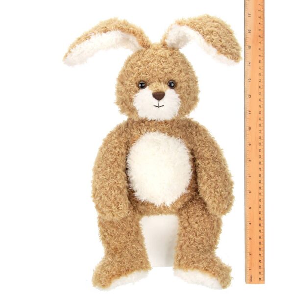 Brown plush bunny toy beside a ruler for size.
