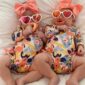 Twin babies in tropical outfits with sunglasses