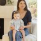 Woman with baby sitting indoors on chair.