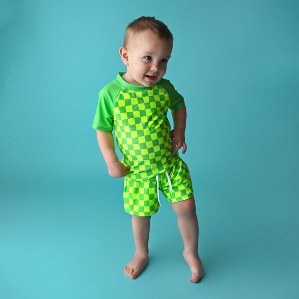 gigi and max brad green neon swim set Child in green checkered outfit on blue background