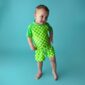 Child in green checkered outfit on blue background