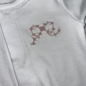 White garment with pink floral embroidery design