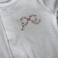 White garment with pink floral embroidery design
