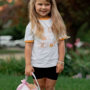 Child holding trick-or-treat basket outdoors.