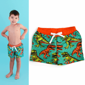 Boy wearing dinosaur-themed swim trunks.