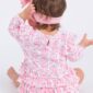 Baby in pink pumpkin-patterned dress, pink headband