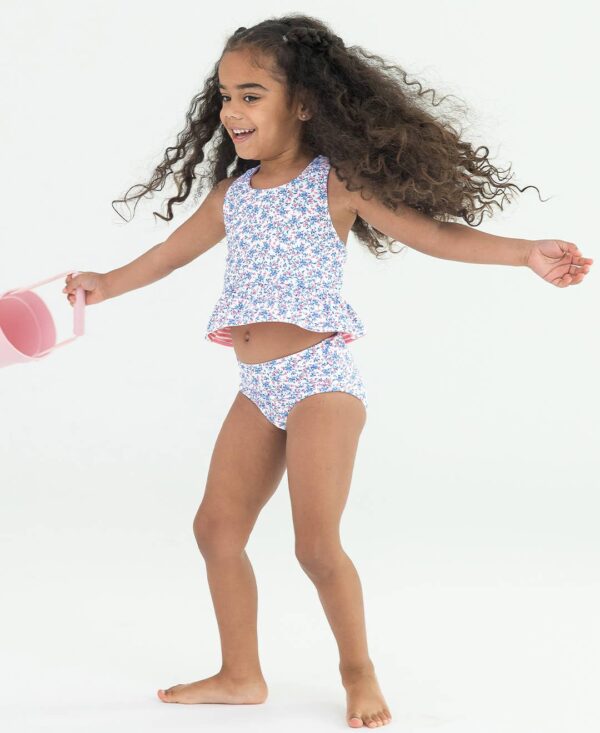 rufflebutts cottage tea time reversible peplum tankini Child in floral swimsuit holding a pink bucket