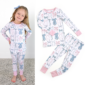 Girl wearing bow-patterned pajamas, matching set displayed.
