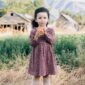 Child holding apple in a field