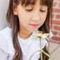 Girl in white dress with a flower.