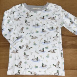 Duck print toddler shirt on wooden surface.