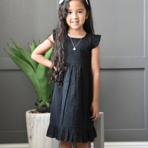 Girl in black dress with plant background.