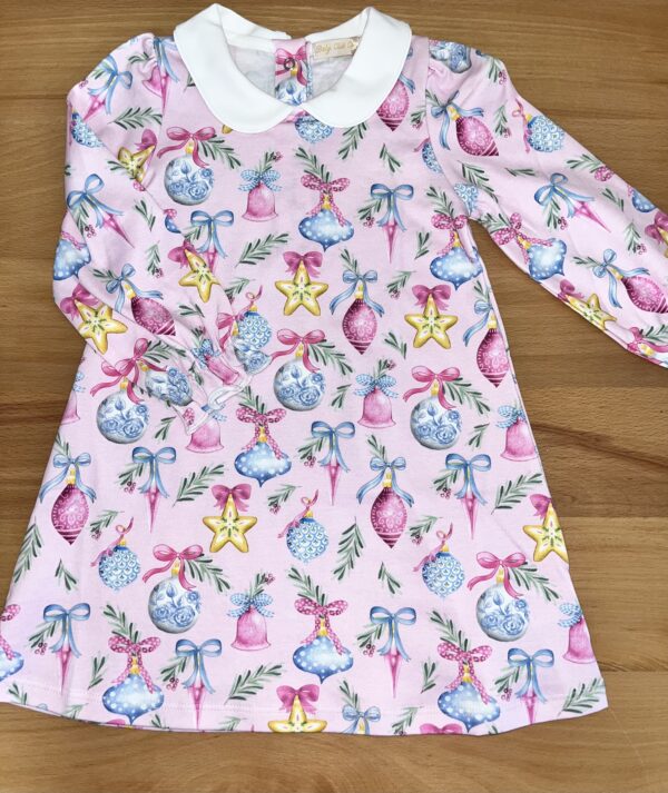 Pink children's dress with Christmas ornament pattern.